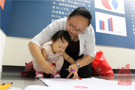 图为本次活动最小参赛者在家长带领下绘制禁毒作品