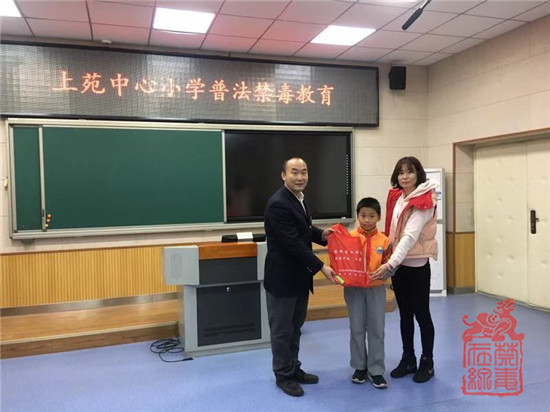 兴寿禁毒社工宋歌为学生发放禁毒宣传资料